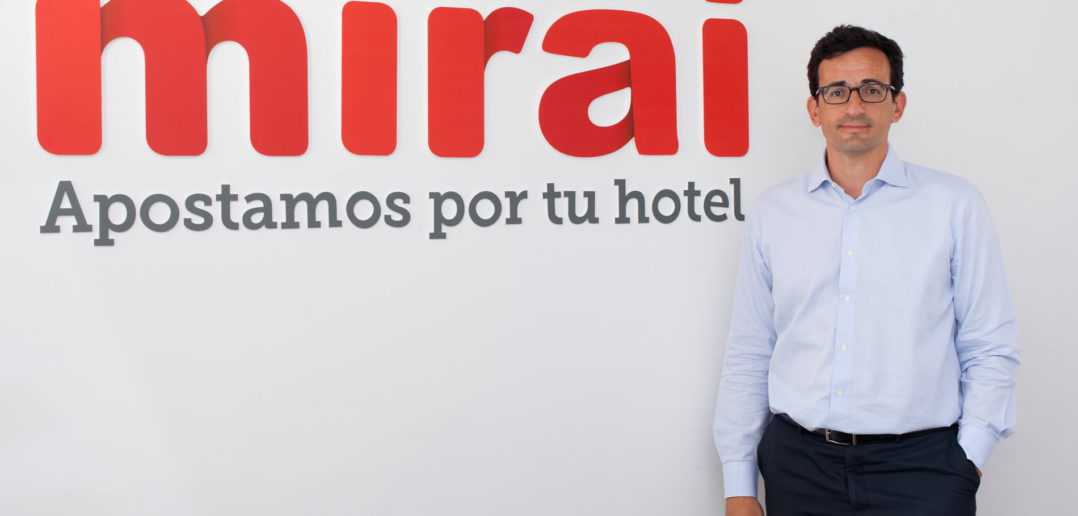 Mirai CEO Pablo Delgado poses in front of his company's logo