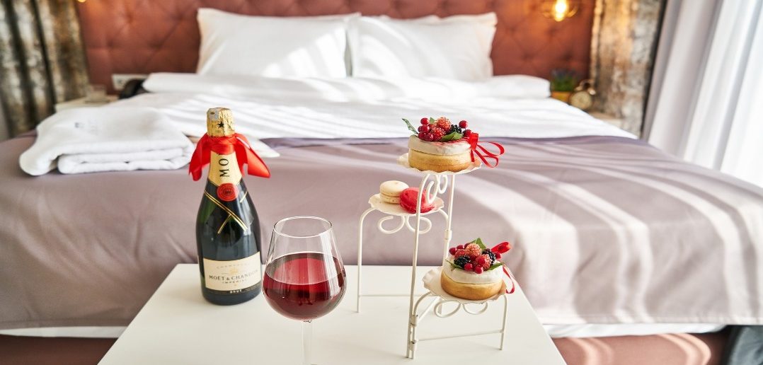 A hotel room with cupcakes and wine