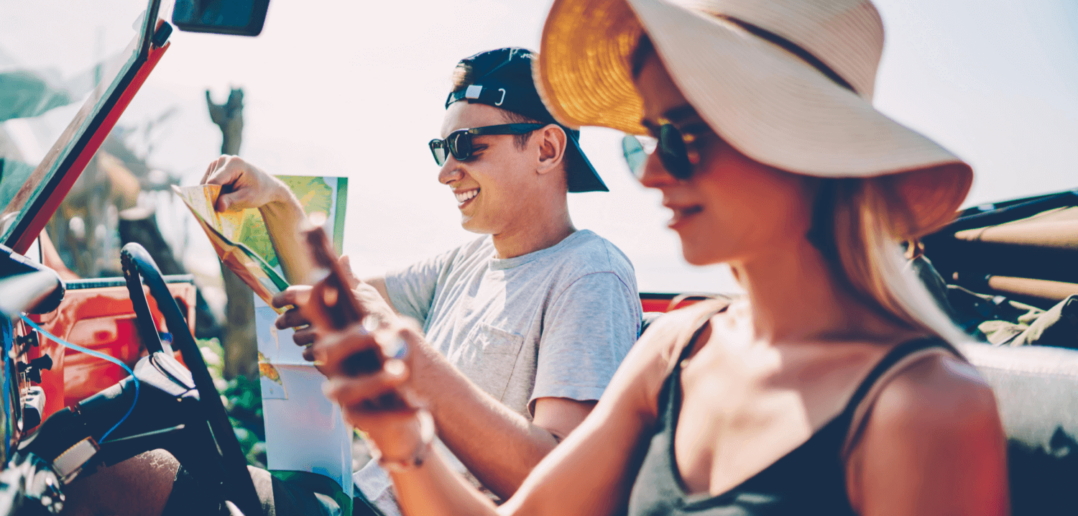 Ein junges Paar schaut auf eine Karte und ein Smartphone